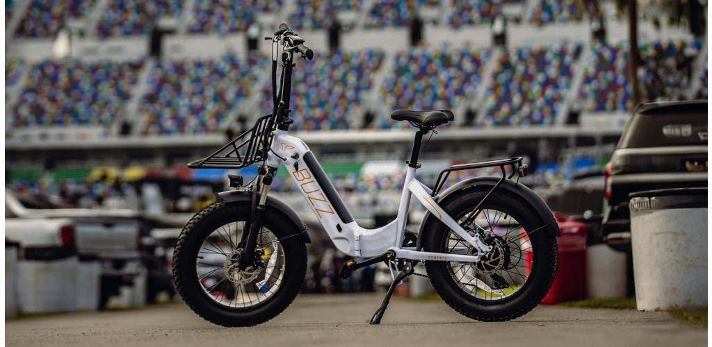 Buzz Centris folding ebike with a motorsports track and fan stands in the background